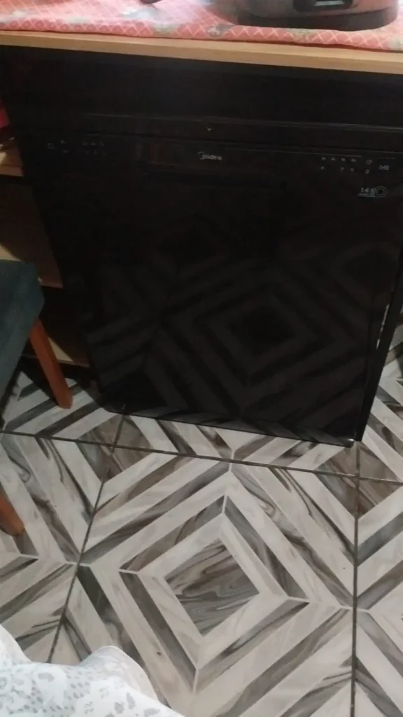 Foto aproximada do interior da lava-louças, mostrando os cestos superior e inferior e o compartimento para talheres. É possível observar recipientes, tampas, potes e outros utensílios acomodados no equipamento, destacando o espaço disponível.